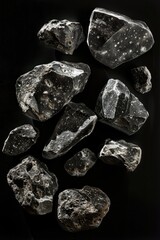 Poster - A group of rocks perched on top of a dark, smooth surface