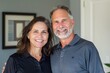 © CogniLens - Portrait of a blissful couple in their 50s wearing a breathable golf polo while standing against stylized simple home office background