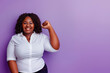 © Lux Images - Confident curvy woman smiling with raised fist isolated on purple background