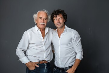 Canvas Print - Two men posing for a photo against a gray background.