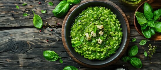 Over rustic wood, a plate with vegan green risotto is seen in a top view image, offering plenty of space for additional elements.