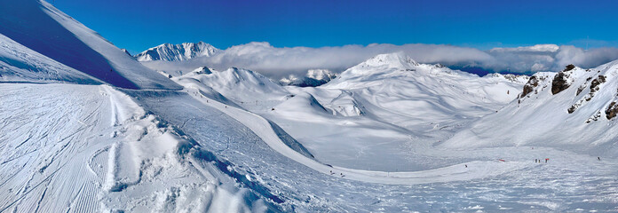 beautiful view on snowy mountain range and ski slope in the French alps in Tarentaise resort under blue sky