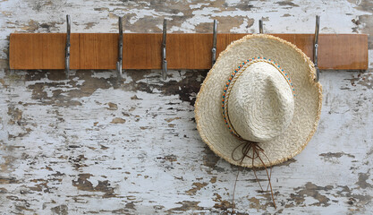 Poster - hanger with hooks with straw hats on an old wooden wall