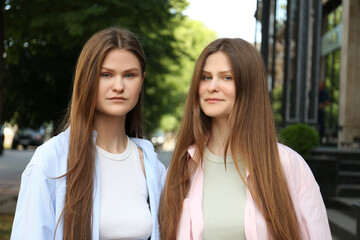 Canvas Print - Portrait of two beautiful twin sisters outdoors