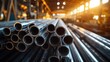 © Meow Creations - Steel pipes stacked at industrial construction site with blurred lights. Concept of manufacturing, building materials, infrastructure development