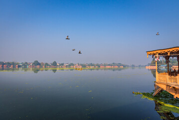 Wall Mural - View of pristine Nigeen Lake which is connected to Dal Lake in Srinagar, India. It is a popular tourist destination with many houseboats for tourist accomodation and shikara boats.