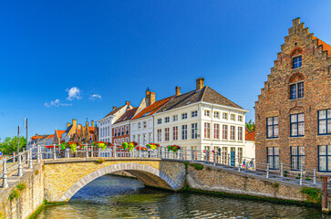 Wall Mural - Bruges cityscape, Sint-Annareibrug stone Bridge, Sint Annarei water canal of Reie river, medieval buildings in Bruges city historic centre, embankment in Brugge old town, Flemish Region, Belgium