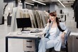 © nazariykarkhut - Businesswoman working at a desk in a showroom with tiles displayed