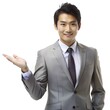 © Tekin - asian business people man good looking in studio. businessman in grey suit confident presenting or showing open hand palm with copy space for product isolated on white background.