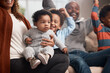 © Courtney/peopleimages.com - Excited, black baby and family on sofa for fun, yes and cheering in living room. Parents, children and happiness at home for victory, relationship development and security on couch with support