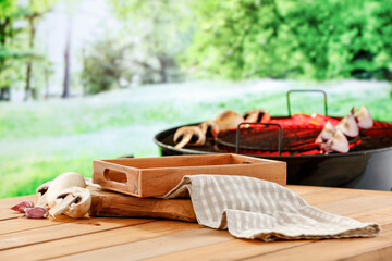 Canvas Print - Grilling in green garden concet with wooden table with copy space for products and vegetables and grill background.