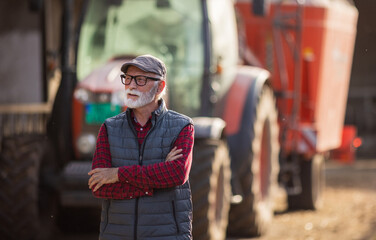 Wall Mural - Farmer standing in front of tractor on cow farm