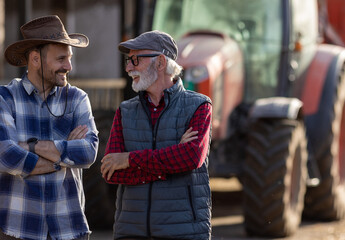 Wall Mural - Two farmers in front of tractor on cattle farm