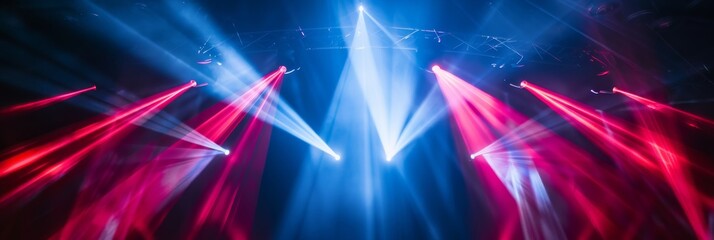 Poster - A dark stage is illuminated by multiple spotlights, casting intersecting beams of blue and red light across the space