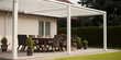 Taras w ogrodzie - altana, pergola. Nowoczesne meble ogrodowe - stolik i stołki wśród natury