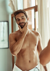 Poster - Man, bathroom and self care in mirror in morning for grooming routine, cosmetics and skincare for beard. Person, reflection and cleaning face for glowing skin, hygiene and happy with facial treatment