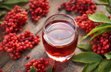 Sticker - A glass of red elderberry syrup on a table