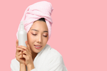 Sticker - Young Asian woman with bottle of cream on pink background, closeup