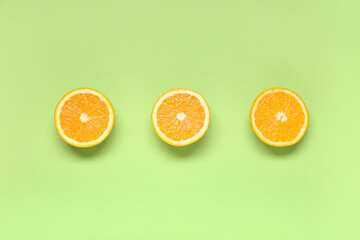 Poster - Composition with ripe tasty halves of oranges on green background