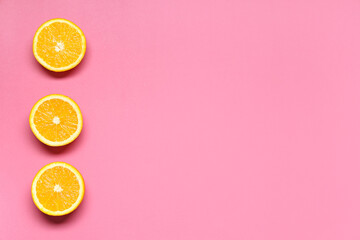 Poster - Composition with ripe tasty halves of oranges on pink background