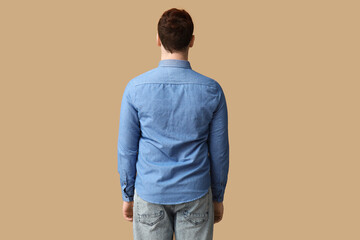 Poster - Young man in stylish blue collar shirt on brown background, back view