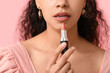 © Pixel-Shot - Young African-American woman with lipstick on pink background, closeup