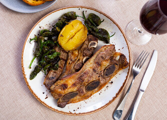 Wall Mural - Steak churrasco with slices of fried potato and little green peppers served in a plate