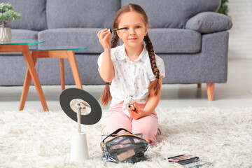 Sticker - Cute little girl with mascara and cosmetic bag sitting on carpet in living room