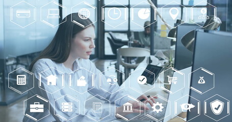 Poster - Image of business and finance icons over caucasian businesswoman using computer at office desk