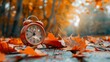 © Sea - Daylight Saving Time. Alarm clock and orange color leaves on wooden table. Autumn time. Fall time change. Autumn leaves fall and winter approaches, the concept of daylight saving time.