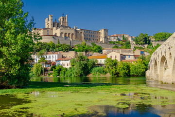 Cathedral Saint-Nazaire-A river runs through a town with a castle in the background