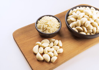 Close up of stacked peeled raw garlic and ground garlic on two black bowls and wooden cutting board, South Korea
