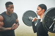 © DavisShared/peopleimages.com - Fitness, weights and coach with woman in nature for arm strength, muscles and tone. Sports, fog and male personal trainer helping female athlete with dumbbell for lifting exercise in outdoor field.