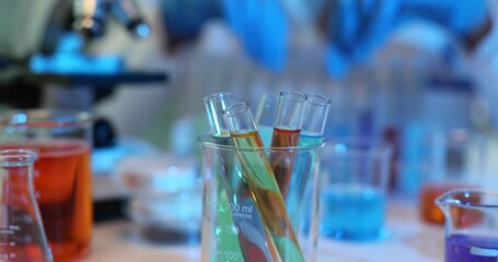 Wall Mural - Glass tubes with colored liquid against laboratory worker