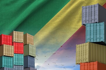 Congo flag and big stack of shipping cargo containers in docks with sky background close up