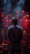 © Fay Melronna  - Back view of a performer standing on stage with dramatic red lighting, ready to entertain an audience in a vibrant setting.