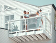 © peopleimages.com - Family, smile and parents with kids on balcony in morning for scenery, holiday accommodation or memories. People, travel and low angle in home on weekend trip for bonding, vacation and happy together