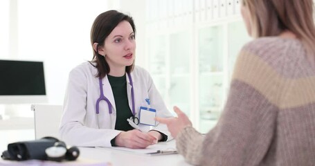 Wall Mural - Doctor with stethoscope listens to female patient in clinic