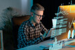 © puhhha - Man In Glasses And Plaid Shirt Analyzing Data On Digital Interface In Modern Office Setting, Representing Technology, Innovation, And Data Analysis. Concentrated Professional Working With High-Tech