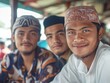 © Luismartin_fit - Three young men in traditional attire smiling warmly in a casual, cultural setting.