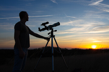 Wall Mural - amateur astronomer observing solar eclipse and sun with a telescope and special solar filter.