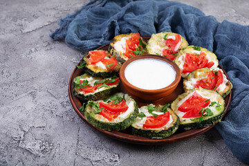 Wall Mural - Fried zucchini with sour cream sauce, tomatoes and greens