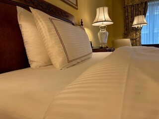 comfortable large bed with luxury bedding in hotel room