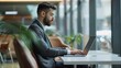 © Shozib - Serious businessman working on laptop in modern office cafe, using wireless internet for online tasks. Demonstrates focused, successful attitude in corporate setting
