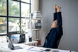 © Wasana - A man in a suit is stretching his arms and legs while sitting at a desk