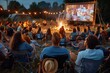 © Milos - A diverse group of friends enjoy an evening outdoor cinema experience, sitting around a cozy campfire and watching a movie projected on a large screen under the night sky.