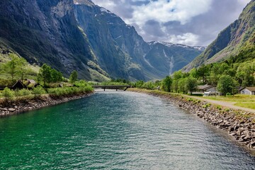 Wall Mural - Naeroydalselvi river flowing in Gudvangen village on a sunny day in Aurland, Vestland county, Norway