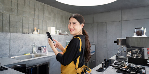 Smiling Barista in Modern Industrial Coffee Shop Using Digital Tablet for Orders