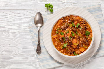 Canvas Print - beef barley soup in a bowl, top view