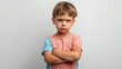 © Natali - Mad male kid, angry little boy standing with his arms crossed, and looking at the camera with upset face expression. Unhappy toddler, studio shot, annoyed and frustrated child emotion